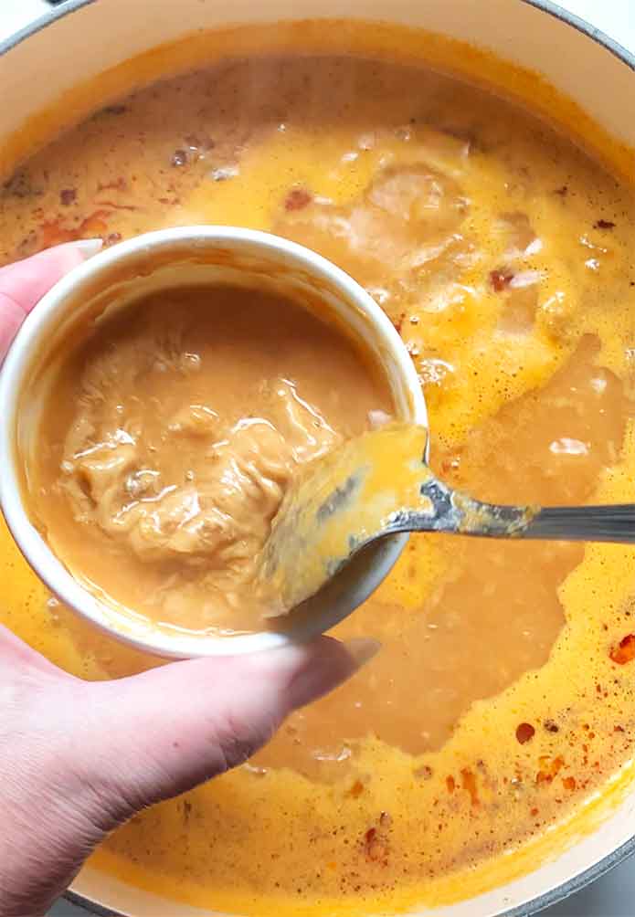 Tempering the peanut butter with some hot soup.