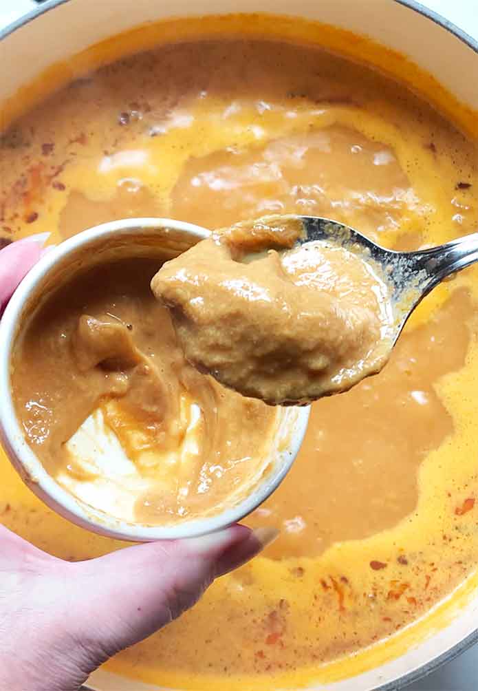 Adding the loosened peanut butter to the soup.